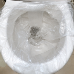 水嚢用に使用するごみ袋を便器にセットしている